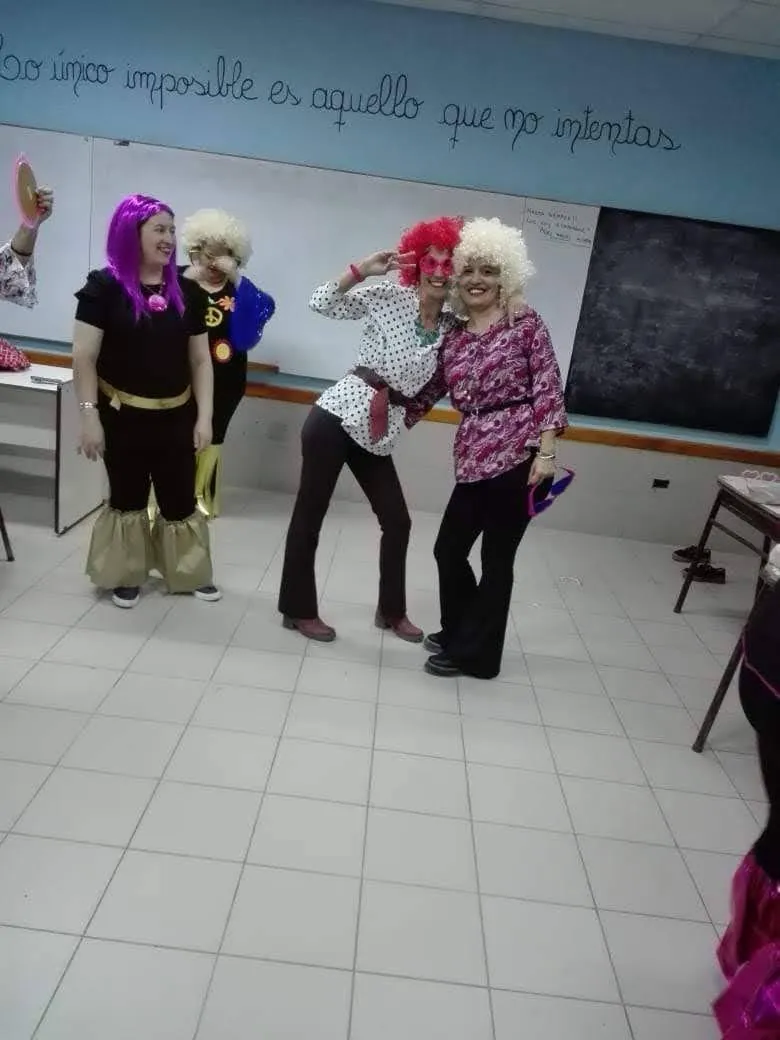 Compañeras disfrazadas en el aula, con la frase en la pared